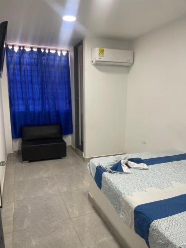 1 Schlafzimmer mit 2 Betten, einem Stuhl und einem Fenster in der Unterkunft Américas al límite in Cúcuta