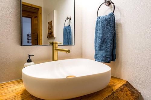 uma casa de banho com um lavatório branco e um espelho. em Luxury cabin, hot tub, slopes, lake & VIEWS! em Fawnskin