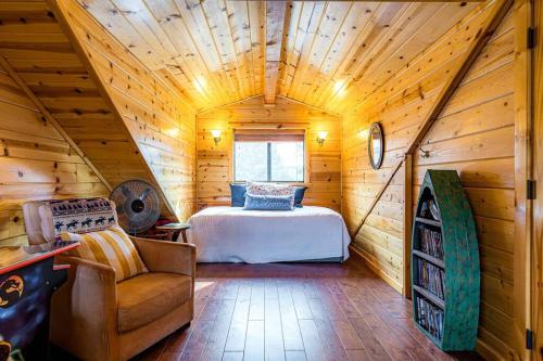 um quarto com uma cama num chalé de madeira em Luxury cabin, hot tub, slopes, lake & VIEWS! em Fawnskin