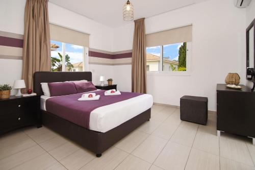 Nissi Sapphire Villa في أيا نابا: غرفة نوم عليها سرير وفوط