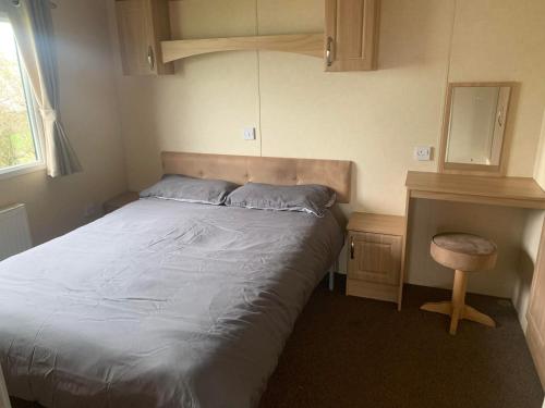 een kleine slaapkamer met een bed en een bureau bij Natalies Retreat Skipsea Sands in Ulrome