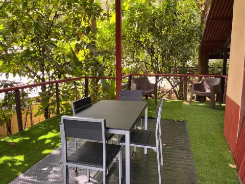 a table and chairs on a patio with grass at Chilamate Rainforest Eco Retreat in Puerto Viejo