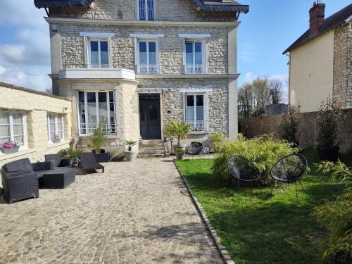 a large stone house with a patio in front of it at Le Gîte Senlisien in Senlis