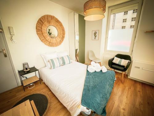 une chambre avec un lit, une chaise et une fenêtre dans l'établissement Le Studio Cosy, à Périgueux