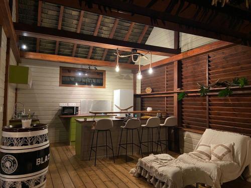 a kitchen with a bar and stools in a room at Bungalow L’Eden in Les Abymes