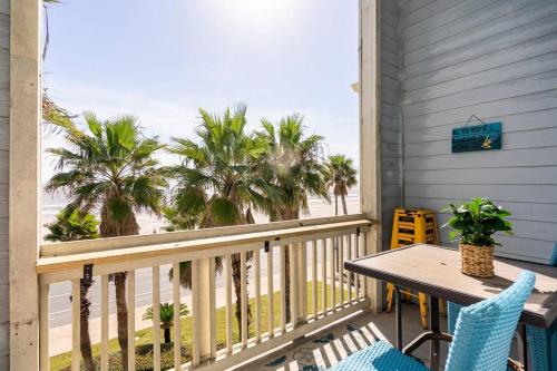 a balcony with a table and chairs and the beach at Oceanfront at The Dawns in Galveston