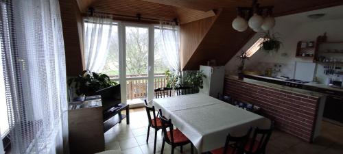 uma cozinha com mesa e cadeiras num quarto em Várkapitány-lak em Csesznek