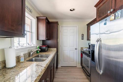 a kitchen with a stainless steel refrigerator and wooden cabinets at Oceanfront at The Dawns in Galveston