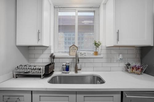 a white kitchen with a sink and a window at Chicago Charm in Chicago