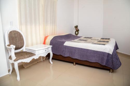 - une petite chambre avec un lit et une chaise dans l'établissement Casa Blanca, Hermosa, Amplia, comoda y muy fresca, à Jamundí
