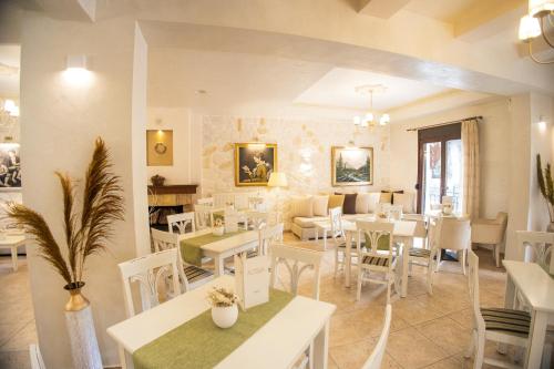 a restaurant with white tables and chairs and a dining room at Hotel Agelis in Kala Nera