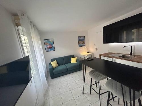 Il comprend un salon avec un canapé bleu et une cuisine. dans l'établissement Magnifique studio au bord de mer, à Nice