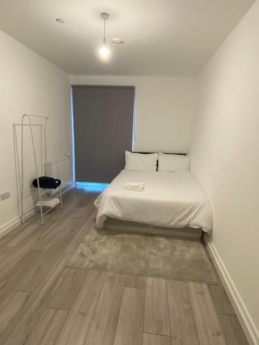una camera con letto e pavimento in legno di 2 Bed Penthouse-Riverside View in East London a Barking