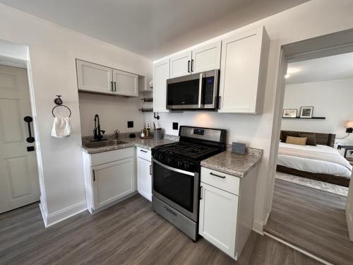 eine Küche mit weißen Schränken und ein Bett in einem Schlafzimmer in der Unterkunft Flexhome East Side 1BR Apt EN1 - READ INFO in Milwaukee