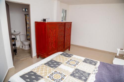 - une chambre avec une commode rouge et un lit dans l'établissement Casa Blanca, Hermosa, Amplia, comoda y muy fresca, à Jamundí
