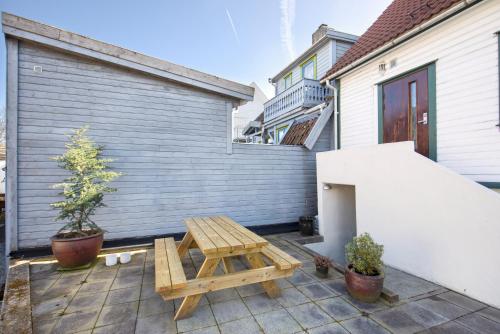 un patio con una mesa de picnic de madera junto a un edificio en Central Studio Apartment in Stavanger en Stavanger