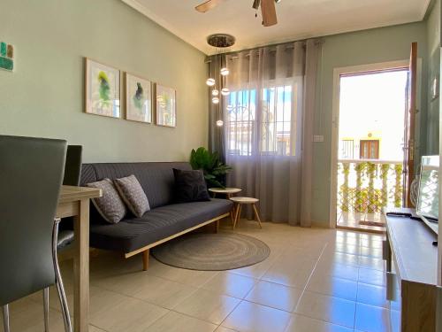 ein Wohnzimmer mit einem Sofa und einem Tisch in der Unterkunft Casa La Florida - Holiday Rental in Alicante