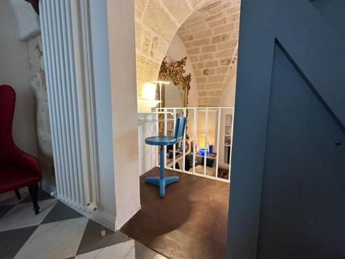 a hallway with a blue chair in a room at Casa Balì in Maruggio