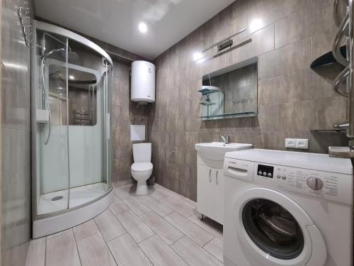 3-room Luxury Apartment on Sobornyi Avenue 133, by GrandHome في زاباروجيا: حمام مع غسالة ومرحاض