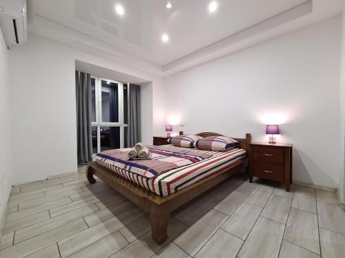 3-room Luxury Apartment on Sobornyi Avenue 133, by GrandHome في زاباروجيا: غرفة نوم مع سرير وخزانة فيها مصباحين