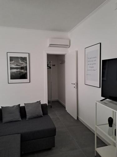 a living room with a couch and a flat screen tv at Novecento Dimore di Poesia in Trani