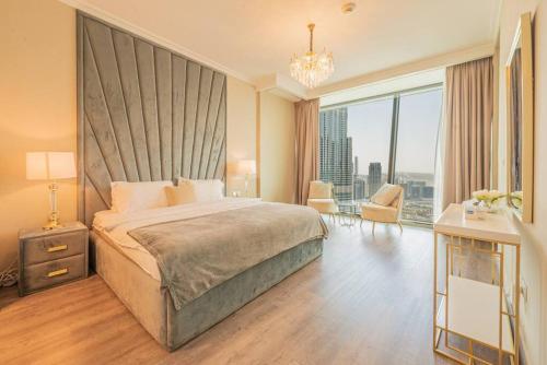 a bedroom with a large bed and a large window at FIRST CLASS 3BR with full BURJ KHALIFA and FOUNTAIN VIEW in Dubai