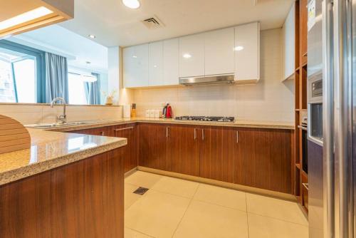 a large kitchen with wooden cabinets and a sink at FIRST CLASS 3BR with full BURJ KHALIFA and FOUNTAIN VIEW in Dubai
