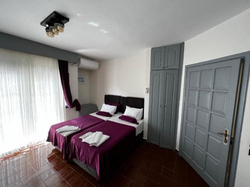 a bedroom with a bed with a purple blanket at Andy's Apart Hotel in Marmaris