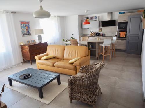 un soggiorno con divano e tavolo di Appartement en Provence-Lubéron - piscine et calme a Volx