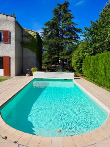une piscine avec de l'eau bleue dans une cour dans l'établissement Appartement en Provence-Lubéron - piscine et calme, à Volx