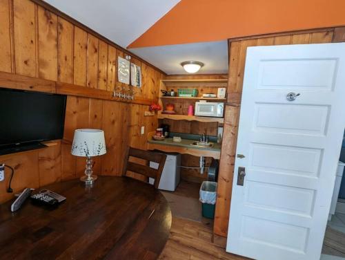 Habitación con mesa, TV y puerta. en Stay Twin Lakes Cabin 2, en Twin Lakes