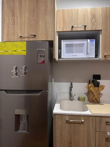 a kitchen with a stainless steel refrigerator and a sink at Entre Rosas y Flores in Guatemala