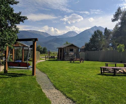 einen Park mit Bänken und einen Spielplatz mit Bergen im Hintergrund in der Unterkunft Stay Twin Lakes Cabin 3 in Twin Lakes