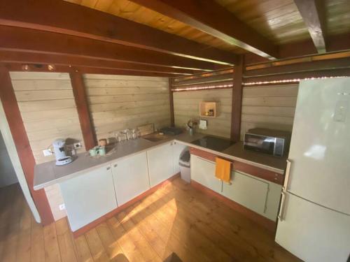 una cucina con armadietti bianchi e pavimenti in legno di Bungalow Ti Zaboka a Les Abymes
