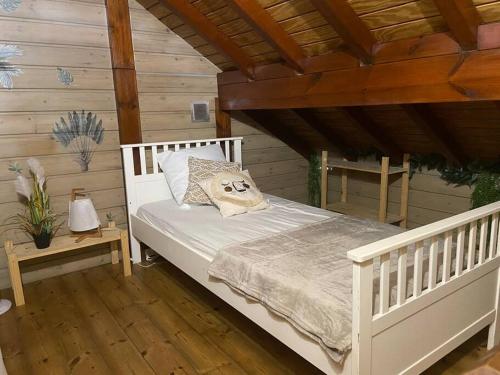 ein weißes Bett in einem Zimmer mit Holzdecke in der Unterkunft Bungalow Ti Zaboka in Les Abymes