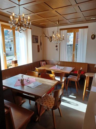 un restaurante con mesas de madera, sillas y lámparas de araña en Hotel Tell en Seelisberg
