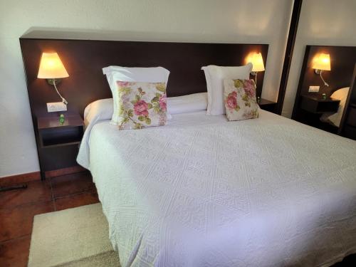 a bedroom with a white bed with two pillows at La Cuadra in Buenavista del Norte