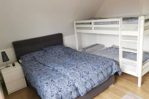 a bedroom with a bed and two bunk beds at 2 Zimmer Wohnung, Wallbox, Balkon, zentral in Himmelpforten