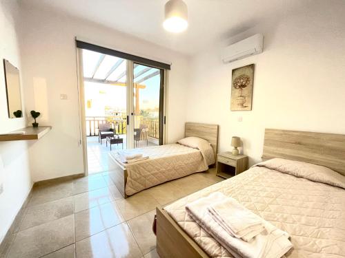 ein Schlafzimmer mit zwei Betten und einem Balkon in der Unterkunft Villa Georgina & Villa Marianda Coral Bay in Coral Bay