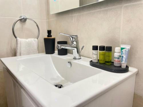 a white bathroom sink with cosmetics on it at Villa Georgina & Villa Marianda Coral Bay in Coral Bay