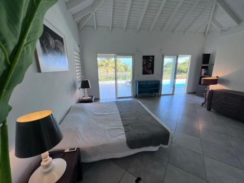 um quarto com uma cama e uma mesa com um candeeiro em Villa Taïana em Saint Martin