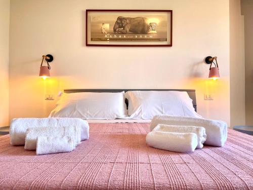 a bedroom with a bed with two white ottomans at Le Corti Sarde Countryside in Bari Sardo