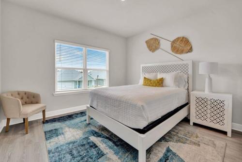 Un dormitorio con una cama y una silla y una ventana. en The Cozy Clam, en Cape San Blas