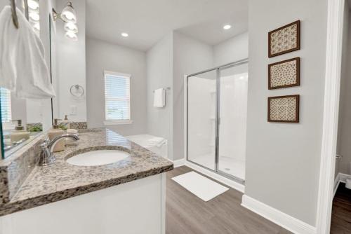 un baño con lavabo y ducha en The Cozy Clam, en Cape San Blas