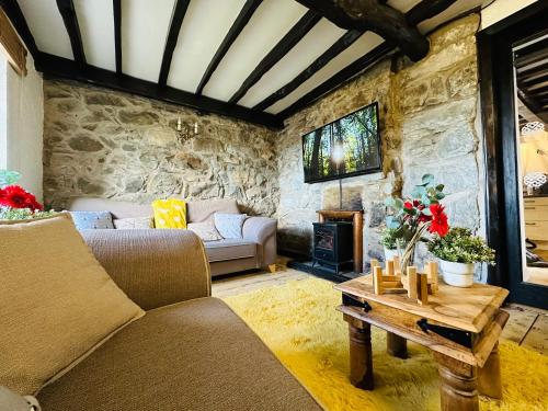 a living room with a couch and a fireplace at Trawsfynydd Stone Cottage in Trawsfynydd