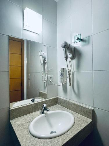 a bathroom with a sink and a mirror at Ibiza Barra Hotel in Rio de Janeiro