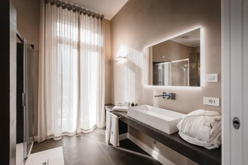 een badkamer met een wastafel en een spiegel bij Villa Adelaide Relais & Wine in Calamandrana