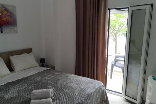 a bedroom with a bed and a sliding glass door at Enastron Cozy & Quiet Apartment in Heraklio