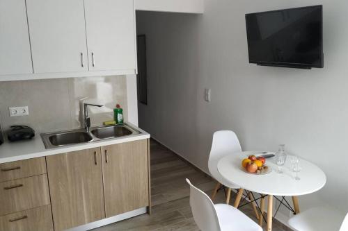 a kitchen with a table and chairs and a sink at Enastron Cozy & Quiet Apartment in Heraklio