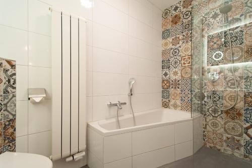 un bagno bianco con vasca e lavandino di CASASdeCASPER - Apartment Alkmaar ad Alkmaar